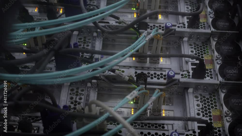 Poster close up fiber optic in server room. bottom view network cables installed in the rack at data center