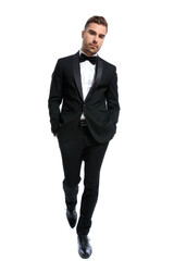 elegant young man in black tuxedo holding hands in pockets