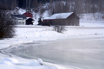 The river is about to freeze. It is very cold and the river is much warmer than the air, therefore the smoke or the damp from the river. Shot at Gol, Norway in February. Minus 20 degreases Celsius.  © SteinOve