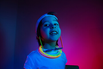 cyberpunk boy child in a white T shirt and large headphones listening to music on the background of...