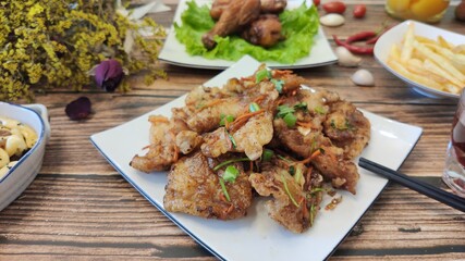A plate of stir-fried meat on wooden table, homemade food