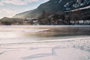 The river is about to freeze. It is very cold and the river is much warmer than the air, therefore the smoke or the damp from the river. Shot at Gol, Norway in February. Minus 20 degreases Celsius. 