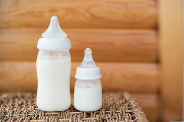 Bottles with breast milk for baby on wooden background. Maternity and baby care concept. Top view. Free copy space. - 411728045