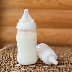 Bottles with breast milk for baby on wooden background. Maternity and baby care concept. Top view. - 411728228