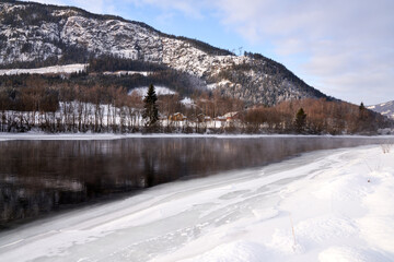 The river is about to freeze. It is very cold and the river is much warmer than the air, therefore the smoke or the damp from the river. Shot at Gol, Norway in February. Minus 20 degreases Celsius.  © SteinOve