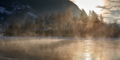 The river is about to freeze. It is very cold and the river is much warmer than the air, therefore the smoke or the damp from the river. Shot at Gol, Norway in February. Minus 20 degreases Celsius.  © SteinOve