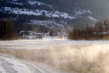 The river is about to freeze. It is very cold and the river is much warmer than the air, therefore the smoke or the damp from the river. Shot at Gol, Norway in February. Minus 20 degreases Celsius.  © SteinOve