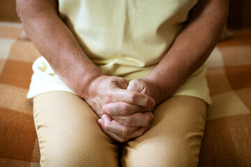 hands in the castle of mature woman sitting on the couch