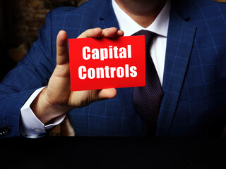 Businessman holding a blank business card. Business concept about Capital Controls with phrase on...