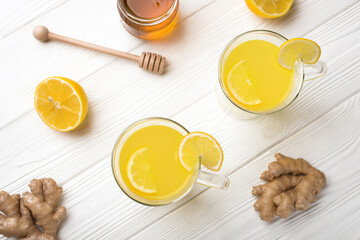 Top view two glass cup of lemon ginger lemonade and ingredients on white wooden background