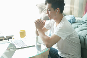 asian young student man entrepreneur wear earphones working with computer studying learning online...