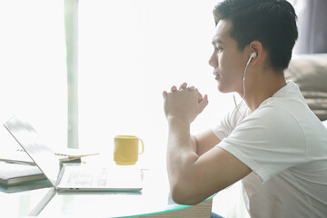 asian young student man entrepreneur wear earphones working with computer studying learning online...