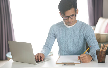 asian young student man entrepreneur working with computer studying learning online at home. e-learning webinar meeting. social distance in covid pandemic