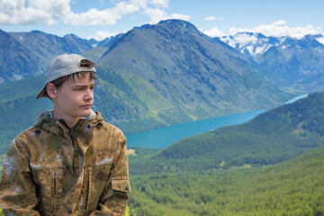 Fototapeta na wymiar Portrait of a teenage boy on a background of mountains.