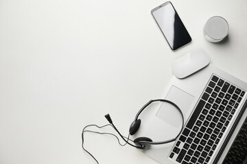 Headset with laptop and mobile phone on white background