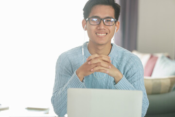 asian young student man entrepreneur wear earphones working with computer studying learning online...