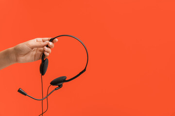 Female hand with headset on color background