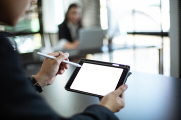Young Asian businessman Sitting and working at a desk With market analysis sheet, Tablet, PC
