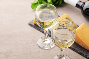 Different types of cheese and wine on gray table