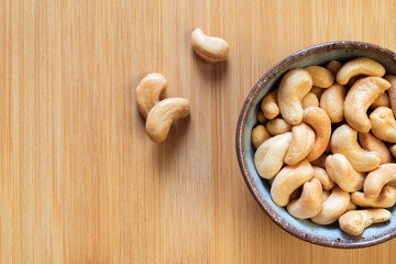 Сashew nuts in a bowl on a wooden background. Copy space. Healthy snack.