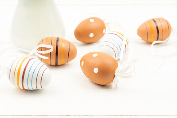 Easter eggs on wooden background. Striped and dotted easter eggs scattered on a table