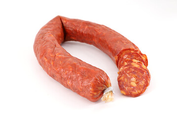 Italian spicy salami sausage with some slices on white background.