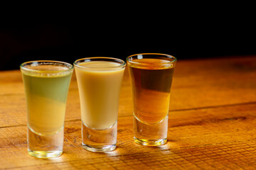 Fresh organic apple cider with apples and cinnamon over dark rustic wooden table background.