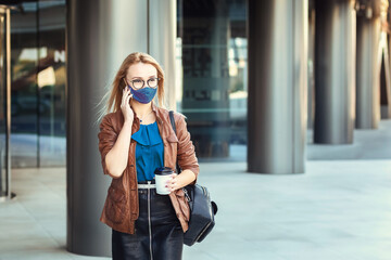Fototapeta premium Woman wearing face mask talking on phone outdoor while commuting