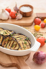 Dish with tasty grilled eggplant on table