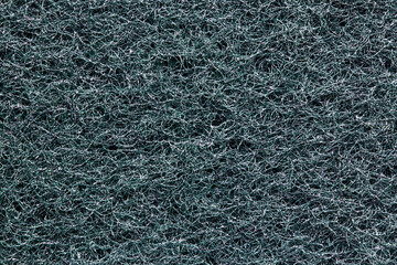 Black sponge texture. Closeup of the rough side of a kitchen sponge for cleaning of of pots and...