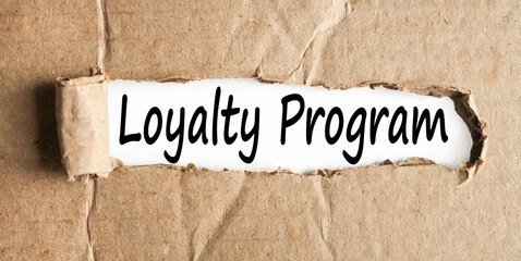 LOYALTY PROGRAM. text on white paper over torn paper background.