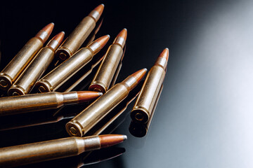 Rifle bullets or cartridges on black shiny background