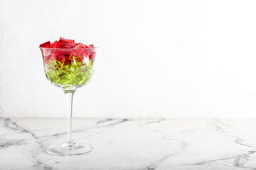 Glass with tasty jelly cubes on white background