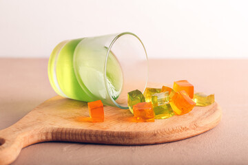 Glass with tasty jelly cubes on table