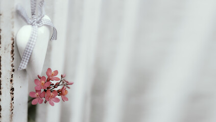 A wooden white heart hanging on  rustic metal fence,background for valentine's day.