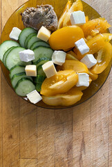 Salad with fresh vegetables. Yellow tomatoes, cucumbers and chesse