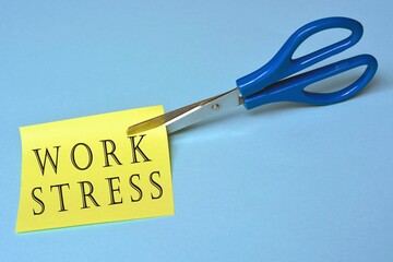 Scissors that cut yellow notepad with work stress text on a blue background