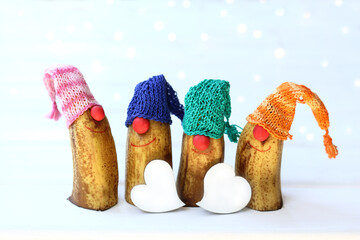 two heart symbols and four cheerful gnomes in colored knitted caps. holiday for all lovers