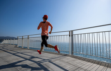Healthy lifestyle fitness sports woman runner running on seaside trail