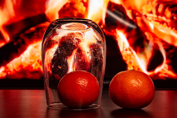 Orange tangerines on the background of the fireplace. Burning firewood.