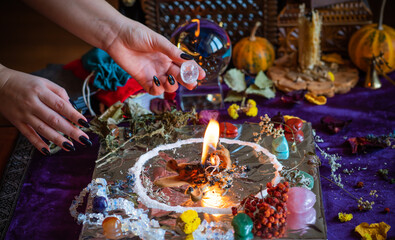 Candle burns a herb on the altar, magic among candles, clean negative energy, wicca  concept - obrazy, fototapety, plakaty