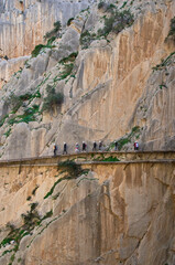 The famous walkway Caminito del Rey in Spain. Visitors with helmets are walking on the path.