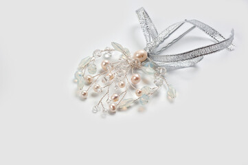 A hair clip on a hairpin in the form of a twig made of silver wire, decorated with river pearls and crystal.