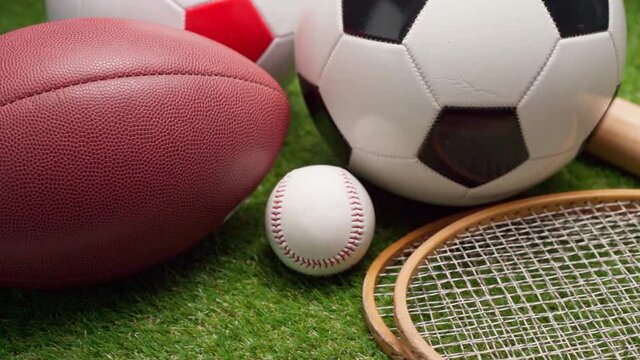 Sport equipment; rackets, balls and baseball bat on grass