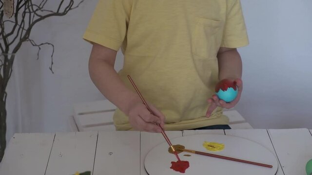 children's hands paint Easter eggs