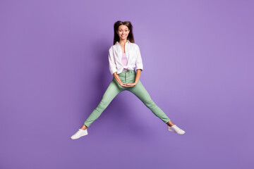 Fototapeta na wymiar Photo portrait full body view of cheerful girl jumping up isolated on vivid purple colored background