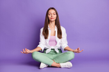 Photo portrait full body view of girl sitting in lotus pose meditating isolated on vivid purple...
