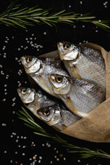 Smoked fish on paper. Dark background