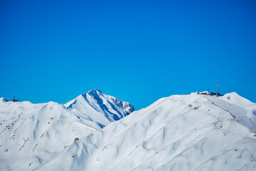Peaks of high French alps covered with snow at winter over blue sky
