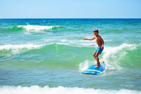 Young 10 Years Old Boy Action Photo Ride Surfboard On A Wave In The Sea